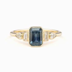 One of a kind ring In stock ready to ship in size 7 1.03ct Deep Teal Blue Montana Sapphire, 6.52x4.56x3.23mm, si1, Heated 0.71ct Light Blue Montana Sapphire, 6.44x4.39x2.46mm, vs1 clarity, Heated Bandwidth: approx. 1.5mm Accent diamond 0.19ctw Low profile bezel setting Ethically sourced solid 14k yellow gold and gemstones Packaged in a recyclable kraft ivory ring box