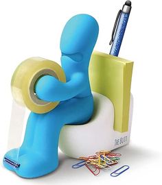 a blue man sitting on top of a desk holding a roll of tape and a pen