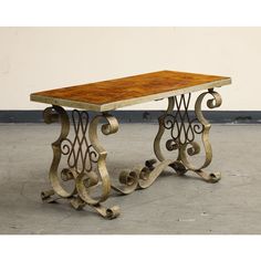 a wooden table sitting on top of a cement floor next to a metal frame wall