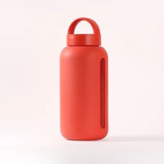 a red water bottle sitting on top of a white table