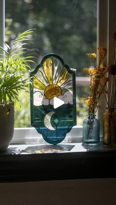 a window sill with plants and vases on it