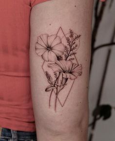 a woman's arm with flowers on it and a geometric tattoo design in the middle