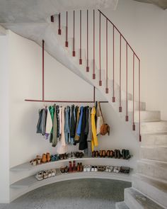 a bunch of shoes are hanging on the wall next to some stairs and a set of stairs