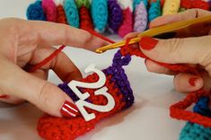 two hands crocheting the letters for a christmas ornament