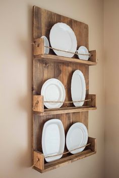 a wooden shelf with white plates on it