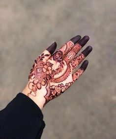 a woman's hand with henna tattoos on it