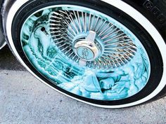 a close up of a tire on the side of a car with blue and white paint