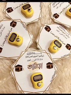 four yellow and black electronic devices on top of a white fur covered surface with arabic writing