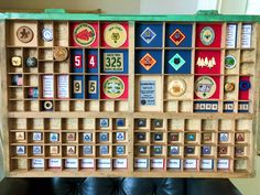 a wooden box filled with lots of different types of badges and numbers on it's sides