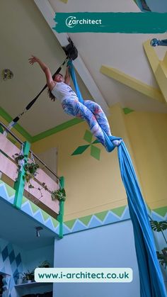 a woman is performing aerial acrobatics on a pole