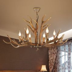 a large antler's head chandelier hangs from the ceiling in a bedroom