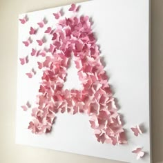 a letter made out of pink paper butterflies on a white card with the letter a in it