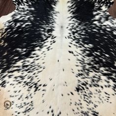 a black and white cowhide rug on a wooden floor