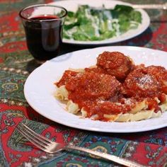 two plates of pasta and meatballs on a table