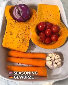 a white tray topped with carrots and other vegetables