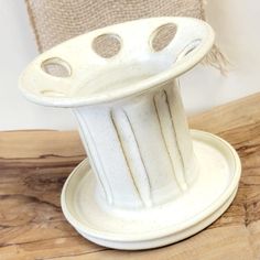 a white vase sitting on top of a wooden table