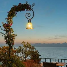 an outdoor dining area overlooking the ocean at dusk