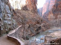 there is a path going up the side of a mountain with a river running through it