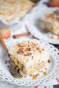 a piece of cake on a white plate with a fork and some apples in the background