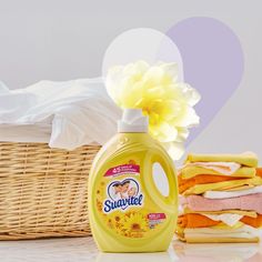 a bottle of sunflower liquid next to some folded towels and a wicker basket