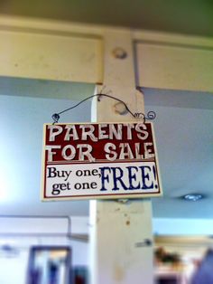 a sign hanging from the ceiling that says parents for sale by one get one free