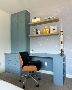 a room with a chair, desk and shelves