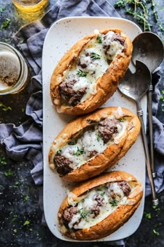 three breads with meat and cheese on them