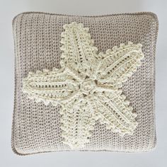 a crocheted pillow with a starfish motif on the front and back side