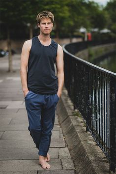 a young man is standing on the sidewalk