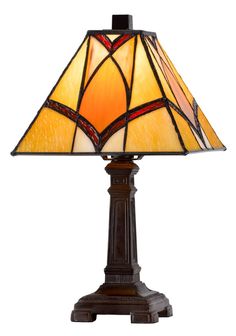 a table lamp with a stained glass shade on it's base and an ornate design