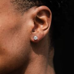 a close up of a person's ear with a small diamond in the middle