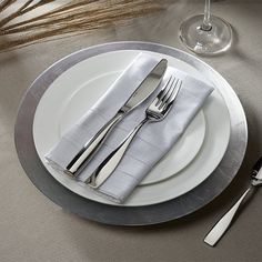 a white plate topped with silverware next to a fork and knife on top of a table