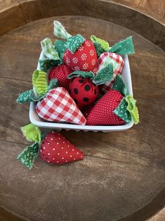 some strawberries are in a white bowl on a table with green and red decorations