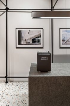 an empty room with two pictures on the wall and a box in front of it