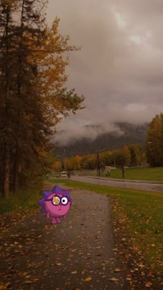 a cartoon character is walking down a path in the fall leaves, with mountains in the background