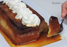 a piece of cake with whipped cream on top is being eaten by a person holding a fork