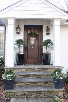 an image of a front door with plants on the steps