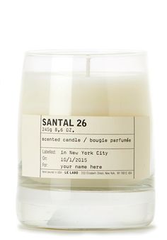 a candle that is inside of a glass container on a white surface with the label santal 26 printed on it