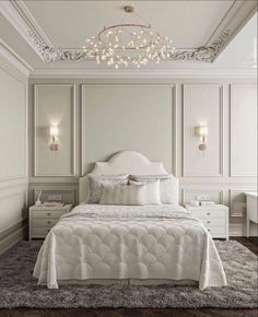 a white bed sitting under a chandelier in a bedroom next to two nightstands