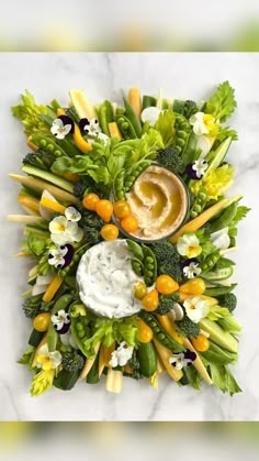 an arrangement of vegetables with dip in the center