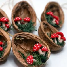 four small mushrooms with red caps and green leaves on them are sitting in the shell