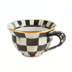 a black and white checkered coffee cup with gold trim