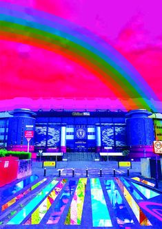 an artistic image of a colorful building with rainbows in the sky and on the ground