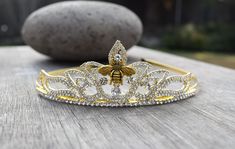 Bee the queen with this bee-autiful tiara! One size fits all, fits children and adults alike.  This tiara features glass rhinestones.  The circumference of the tiara is about 15 inches.   At the highest point on the front, it is a little over 1.5 inches tall.  The metal band is flexible.   Ships in a gift box for easy gift giving! Shipping Details: All items will be shipped First Class by the United States Postal Service. An option to upgrade shipping to Priority or Express Service is available upon checkout for USA orders. You will be provided with a tracking number once your order has been shipped via email. Current processing times are shown in each listing. Shipping within the US typically (but not always), takes 3-6 business days with standard postage. All items will be shipped in gif Queen Bee Crown, Queen Bee Costume, Bee Crown, Bride To Bee, Queens Tiaras, Bridal Jewels, Bee Bee, Crown Gold, Beautiful Tiaras