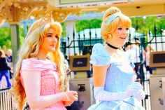 two women dressed as princesses standing next to each other