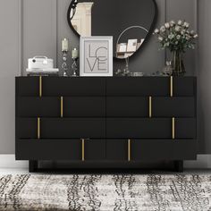 a black and gold dresser with a mirror on top