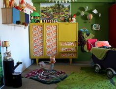 a child's room with green walls and furniture