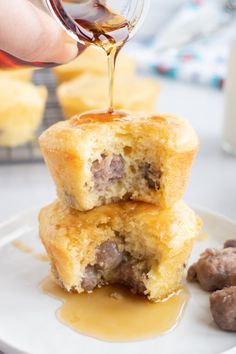 someone is pouring syrup on some meatball muffins that are stacked on top of each other