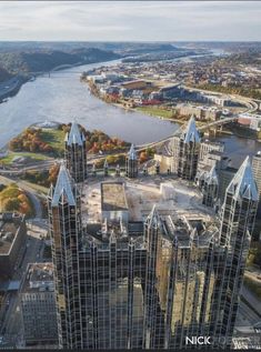 an aerial view of a city with skyscrapers and river in the background, taken from above