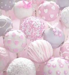 pink and white cake pops with sprinkles are arranged in the shape of hearts